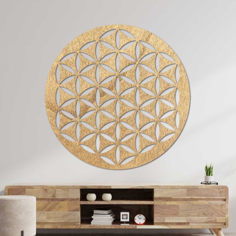 Dřevěná nástěnná dekorace s geometrickým vzorem květu života zobrazená na světlé stěně.