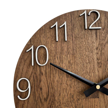 Vyřezávané hodiny ze dřeva s jednoduchým ciferníkem a minimalistickým designem.
