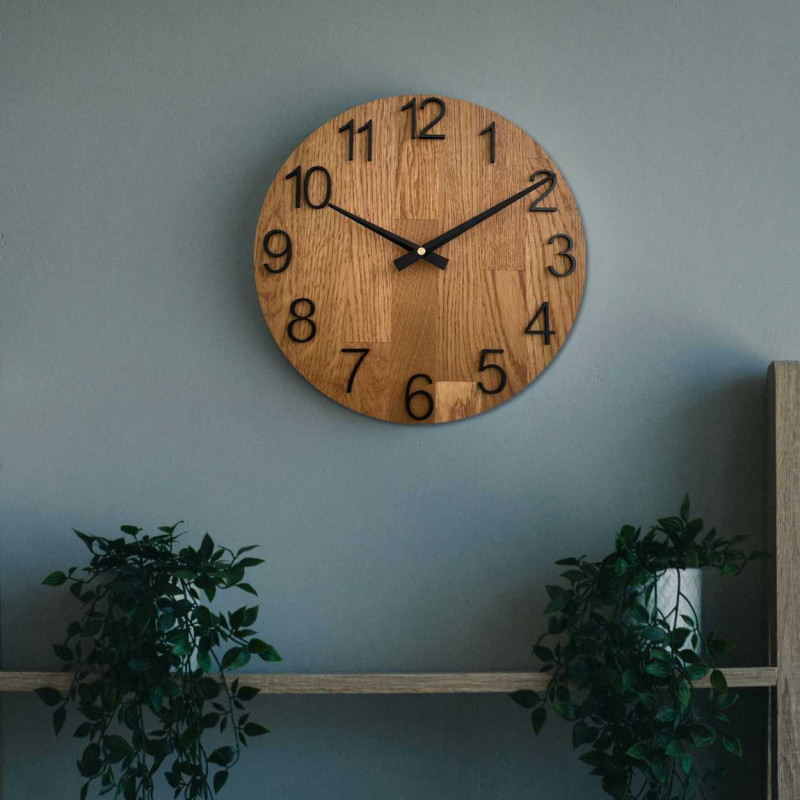 Vyřezávané hodiny ze dřeva s jednoduchým ciferníkem a minimalistickým designem.
