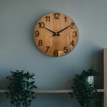 Vyřezávané hodiny ze dřeva s jednoduchým ciferníkem a minimalistickým designem.