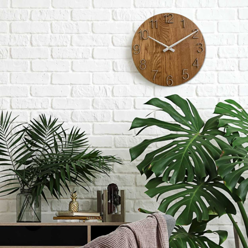 Kruhové hodiny s dekorativním výřezem ve středové části a jemnou kresbou dřeva.