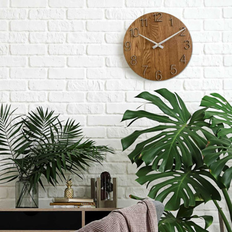 Kruhové hodiny s dekorativním výřezem ve středové části a jemnou kresbou dřeva.