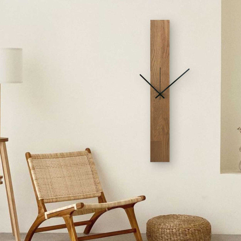 Vertikální dřevěné hodiny s kombinovanými černými a stříbrnými ručičkami bez čísel.